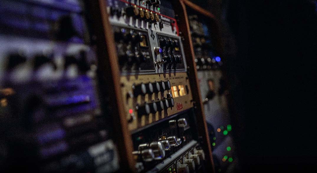 Outboard processing and rack gear glowing in a professional control room